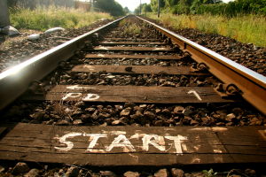 railroad tracks leading into the distance with &quot;start&quot; painted on a tie